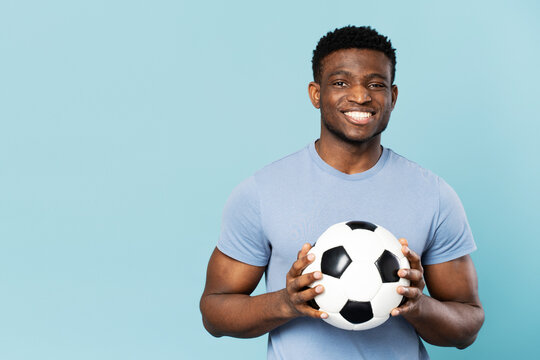 Smiling african american man holding soccer ball isolated on blue background copy space, advertising - Powered by Adobe