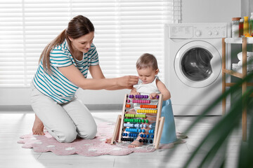 Mother training her child to sit on baby potty indoors
