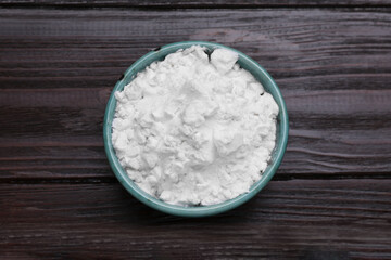 Starch in bowl on wooden table, top view