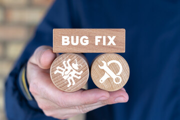 Programmer holding wooden blocks and sees inscription: BUG FIX. Man fix computer, deleting malware,...