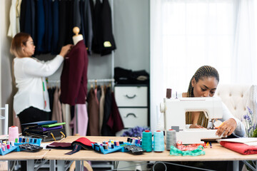 Diverse women fashion designer work design clothes in tailoring atelier.