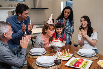 Multi-ethnic big family having birthday party for senior grandmother.