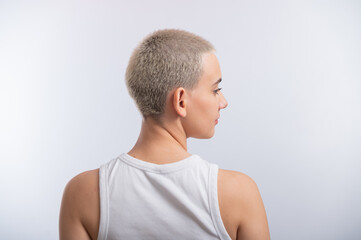 Naklejka premium Pretty young woman with a short blond haircut on a white background.