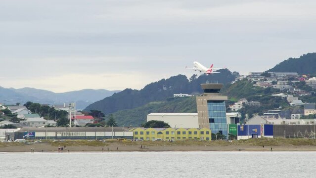 The Wellington Air Traffic Control Tower with an Qantas A320 aircraft taking off the in the background