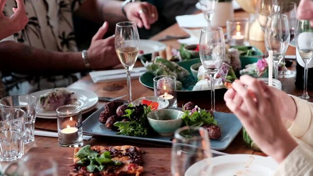 People enjoy a feast around a table eating and drinking