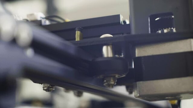 close up of the x, y, axis on a 3d printing machine, 3dprint with filament of bioplastics. bokeh, light shot, cinematic feel and view at technological machinery parts.