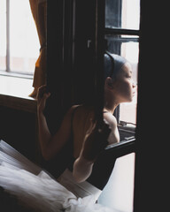 teenage ballet dancer looking out the window