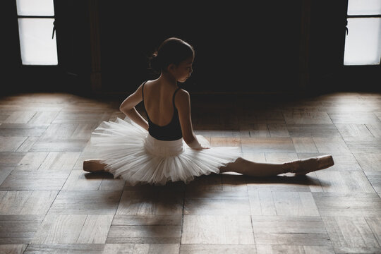 teenage ballet dancer stretching on the floor