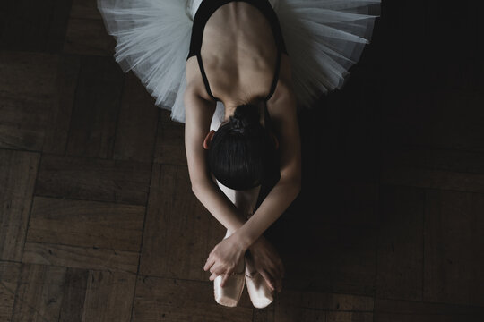 Teenage ballerina stretching on the floor