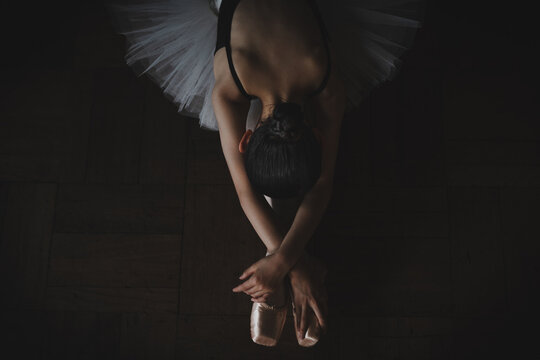 Teenage ballerina stretching on the floor