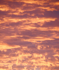 Cloudy sky during sunset with a saturated bright orange color