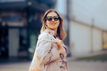 Shopping Woman with a Bag of Fruits in front of Supermarket Store. Shopper using sustainable plastic free bag for groceries 
