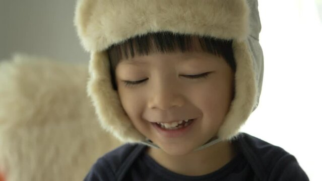 happy little boy wear hat playing and smiling in home, slow motion scene