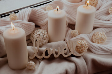 Wooden word love valentines concept Home fragnance concept autumn holidays at cozy home on the windowsill Hygge aesthetic atmosphere on knitted white sweater. Still life of micro moment candid slow