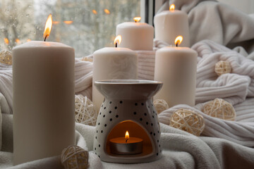 Aroma lamp with essential oil, aromatherapy at home, burning candle, dropping essential oil. Concept of home relaxation and anti stress. Natural Spa treatment Home fragnance at cozy home on the