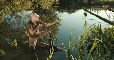 Young man preparing supplies for fishing at lake