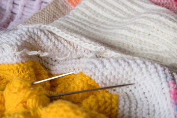  Multi-colored knitted fabric, knitting needles in a ball of yarn.Knitting clothes, plaid.Handmade things, handmade business.