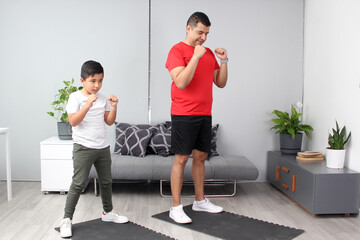 Boxing classes in the living room of his house between dad and son as a student teacher teaches techniques and practices of the sport
