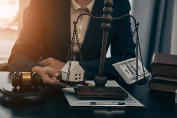 Young beautiful Asian real estate agent uses a small calculator and house models to present and advise clients on buying and selling home designs. real estate business ideas