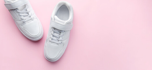 White sneakers on a pink background.