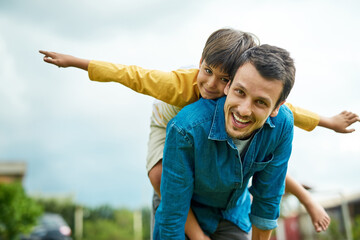 Portrait, children and a son on back of his dad outdoor in the garden to fly like an airplane while...