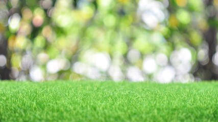 Green artificial grass on natural daylight bokeh blur background