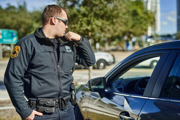 Police, radio and security with a man officer outdoor on patrol while talking to headquarters for a...