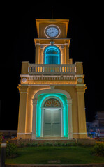 Glowing and illuminated Clock tower on a roundabout in old phuket town at night phuket thailand. 