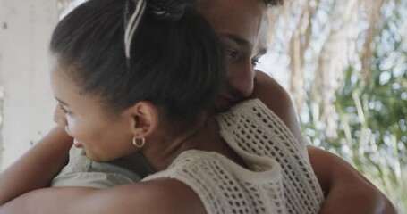 Happy diverse couple smiling and embracing on sunny beach house porch, in slow motion - Powered by Adobe