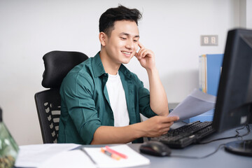 Photo of young Asian businessman working at office