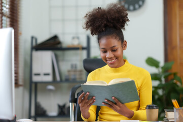 Attractive young black woman are reading book and working at home their leisure and enjoying reading on vacation.