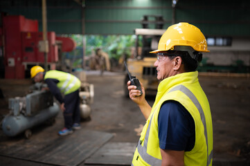 The technician team leader encourages the team who are tired from hard work. in repairing old machinery to return to normal operation in the company's old machinery warehouse