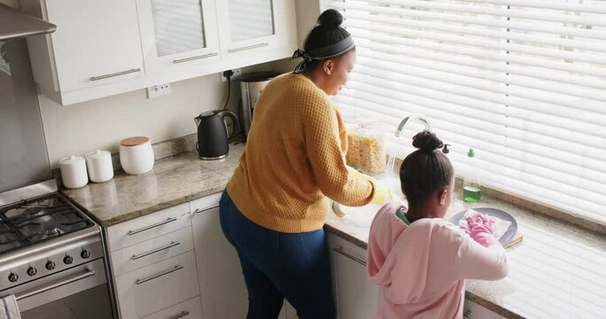 Montage of happy african american mother and daughter enjoying time together at home, in slow motion