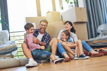 Children, parents and laughing in apartment with box on living room floor with happiness for lifestyle. Family, boxes and excited in new house with investment in a mortgage for saving and wealth.