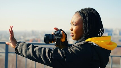 Beautiful young african american tourist woman posing in front of male friend taking photos - Powered by Adobe
