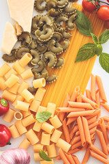 Different types of pasta with ingredients on white background. Cooking pasta concept.