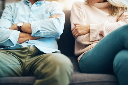 Divorce, angry and couple fight arms crossed due to family law problem in a marriage with conflict in a home lounge. Anger, living room and partner or people frustrated, depressed and mad on a sofa