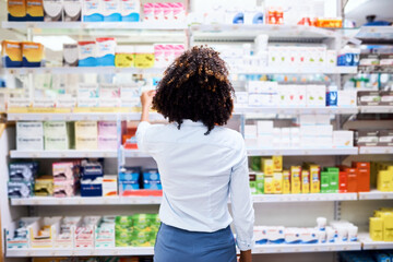 Back, pharmacy and medication with a woman customer buying medicine from a shelf in a dispensary. Healthcare, medical or treatment with a female consumer searching for a health product in a drugstore - obrazy, fototapety, plakaty