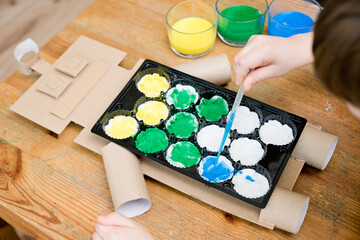 Second chance for packaging. Boy making a robot from used packing materials. Class for therapy of art. Fine motor skils, task of sensorics. Activities at home.