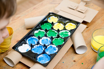 Second chance for packaging. Boy making a robot from used packing materials. Class for therapy of art. Fine motor skils, task of sensorics. Activities at home.