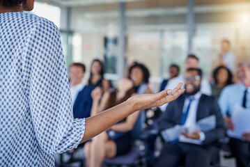Presentation, hand and a woman as speaker at a conference for training or workshop. Business, corporate and a female manager speaking to a crowd at a seminar or convention for leadership or mentoring
