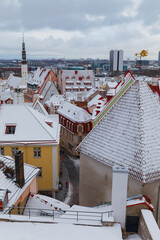 TALLINN, ESTONIA - JAN 15, 2023: Snow-covered roofs of houses in old town of Tallinn after snowfall