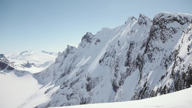 Snow covered rocky mountain peaks, aerial drone view