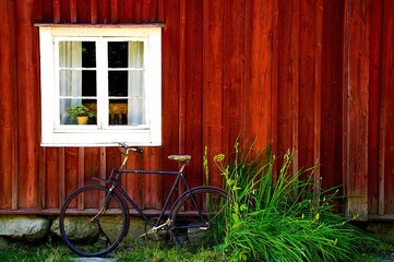 Fototapeta na wymiar Ein Vintage Fahrrad an einer roten Holzwand angelehnt