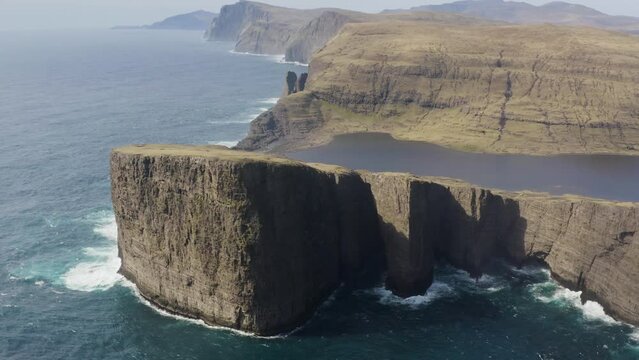 Tr&aelig;lan&iacute;pa Slave Cliff And Leitisvatn Lake Mountain Landscapes In Faroe Islands Of Denmark - aerial drone shot