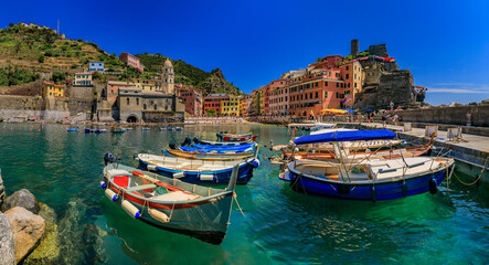 Fototapeta na wymiar Mediterranean Sea with colorful boats and houses in Vernazza, Cinque Terre Italy