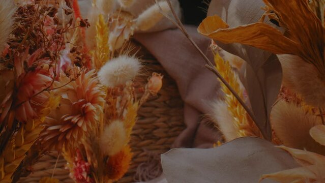 Revealing shot, dried flower fall bouquet and wicker basket, autumn mood