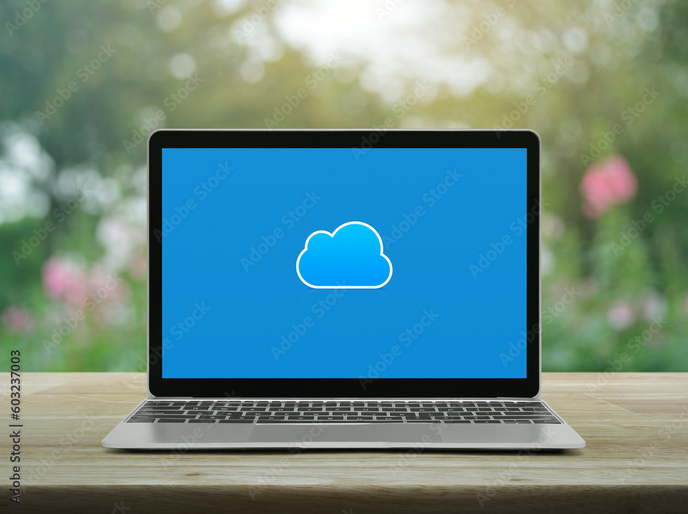 Poster cloud computing icon on modern laptop computer monitor screen on wooden table over blur pink flower 