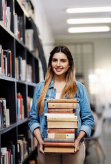 Woman in portrait, college student with stack of books in library and research, studying and learning on university campus. Female person with smile, education and scholarship with reading material