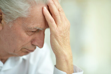 Fototapeta premium portrait of sad thinking senior man posing at home